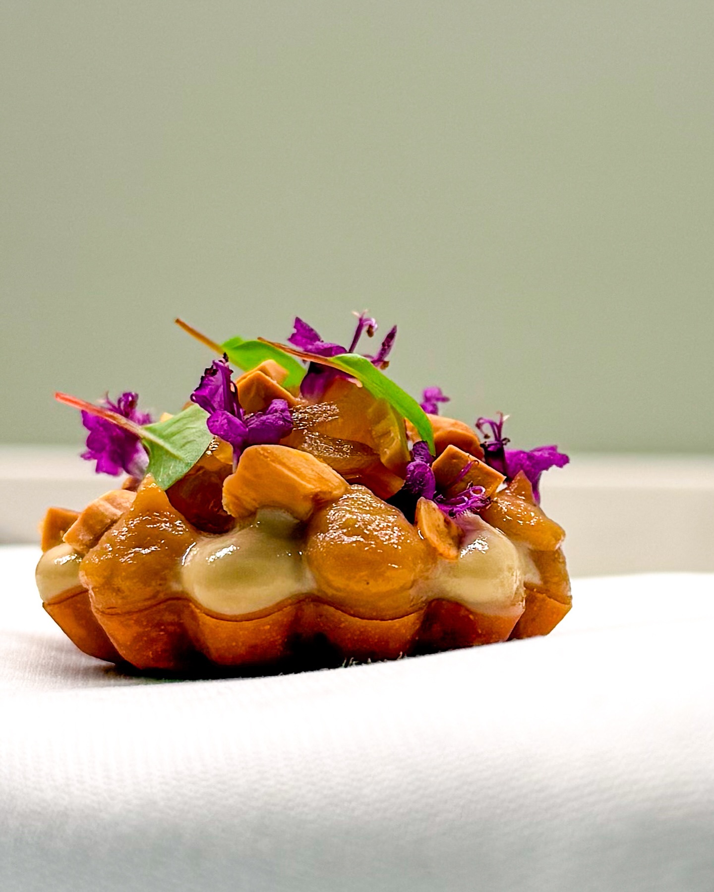 🧅 Tartelette met Roscoff ui, amandel & drop
🇬🇧 Tartlet with Roscoff onion, almond & licorice 

Bijzondere combinatie hè? Dat dacht ik ook! Maar het werkt fantastisch. Het is niet voor niets dat Björn Frantzén dit de ‘holy trinity’ noemt. Deze heerlijke amuse is dan ook bedoeld als een soort throwback naar het bezoek aan zijn restaurant in Stockholm 🇸🇪 

In de tartelette ligt een gebakken plakje foie royale met erop wat gekaramelliseerde Roscoff ui. Rondom staan dotjes crème van diezelfde ui en van room met droppoeder.

Hierop grofgehakte geroosterde amandel en wat bloemen en kruiden 🌿 Neem maar van me aan dat dit een knaller is! Het recept vind je daarom binnenkort zeker op haroldkookt.nl 📌 

✌️